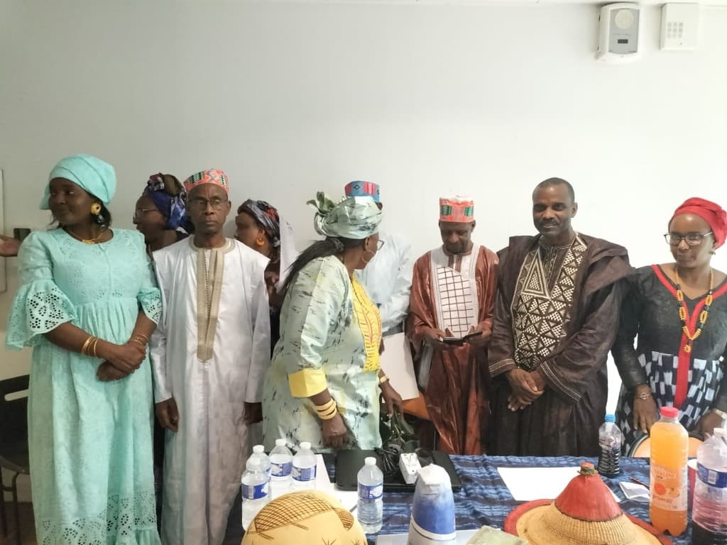 Membres de la communauté peule réunis en tenue traditionnelle avec chapeaux Tengade et calebasses